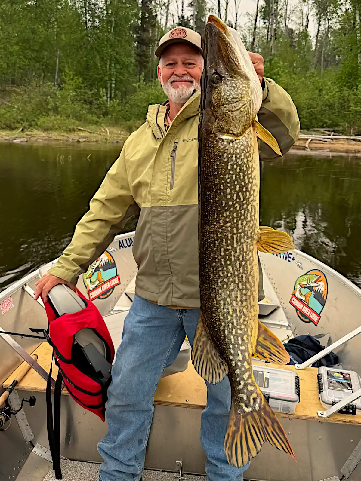 Angler holding a very dark, beautifully patterned trophy Northern Pike in Manitoba, Canada.