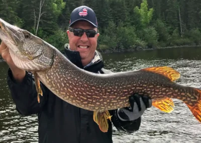 Angler holding a giant Northern Pike caught in Manitoba.
