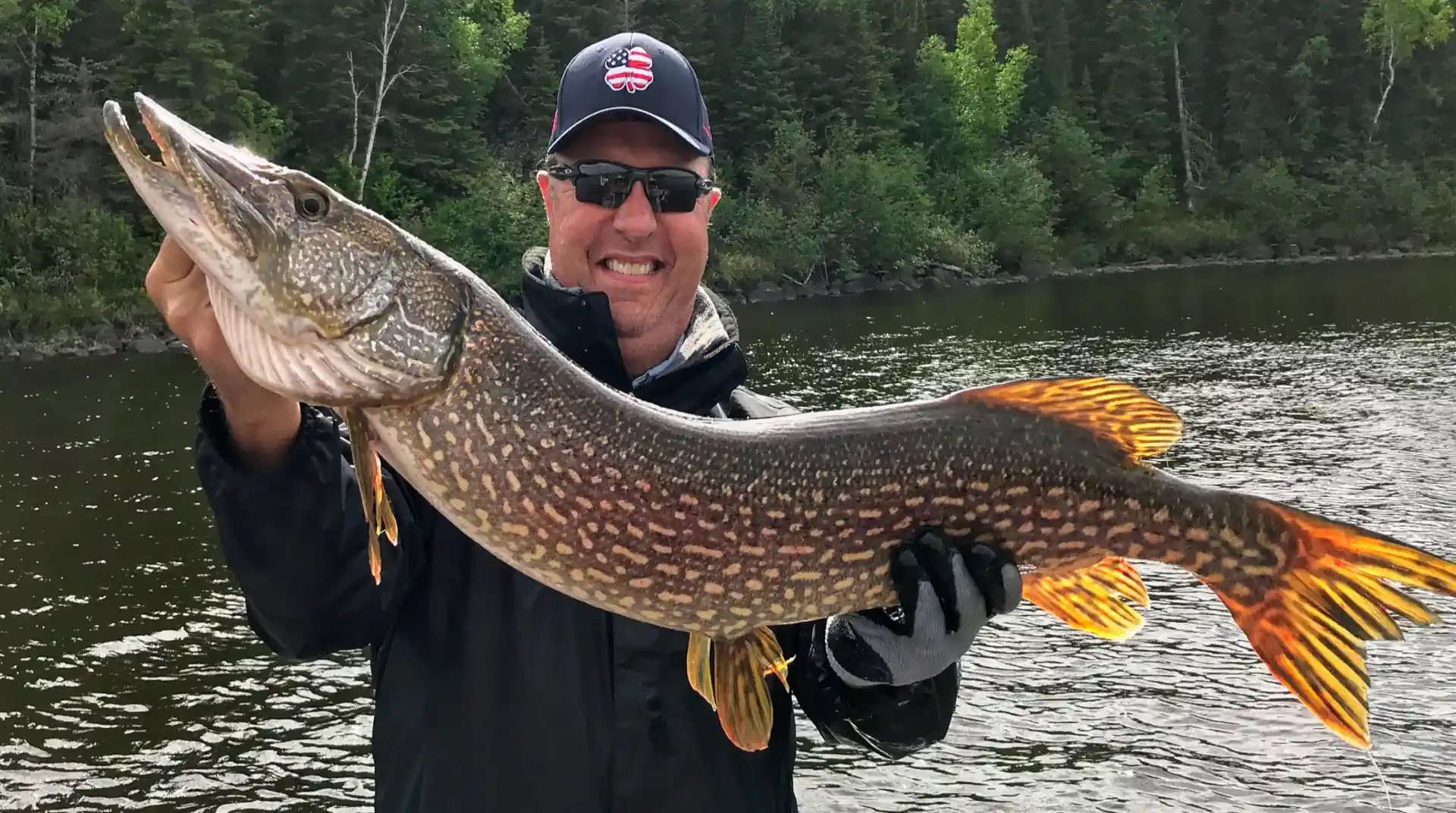 Angler holding a giant Northern Pike caught in Manitoba.