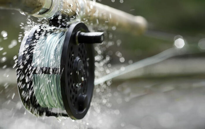 Close-up of fishing gear essentials, including rod and reel for fly-fishing.