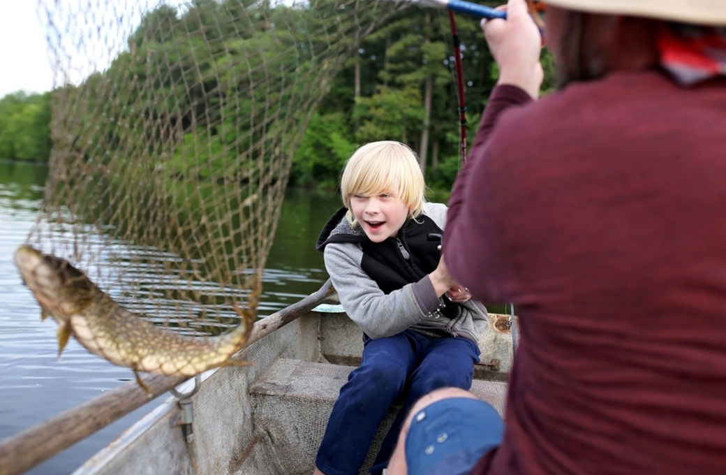 Young child focused on catching a Northern Pike, exemplifying the thrill and education of teaching kids pike fishing.